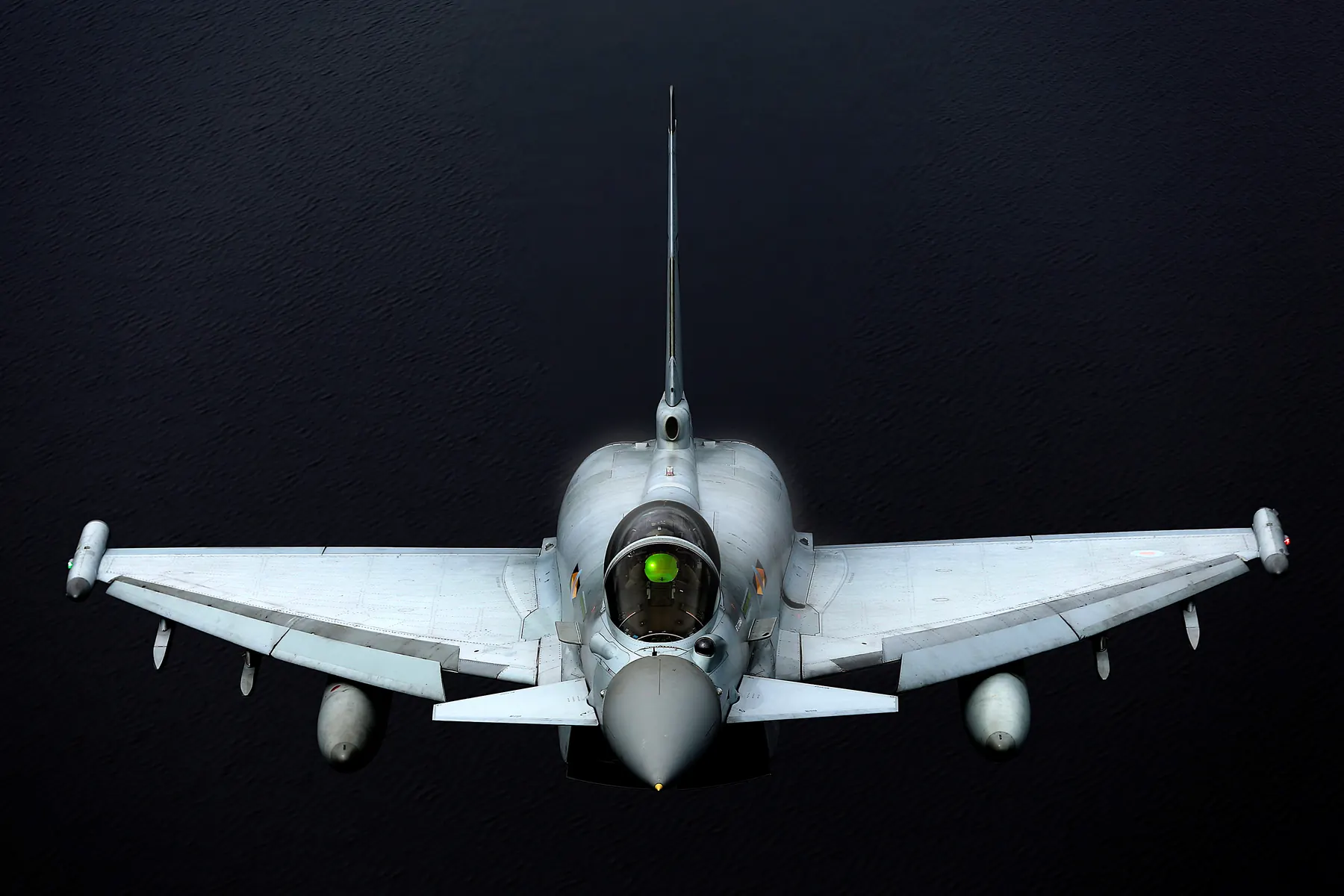 A Eurofighter Typhoon seen head-on in flight against a dark sky
