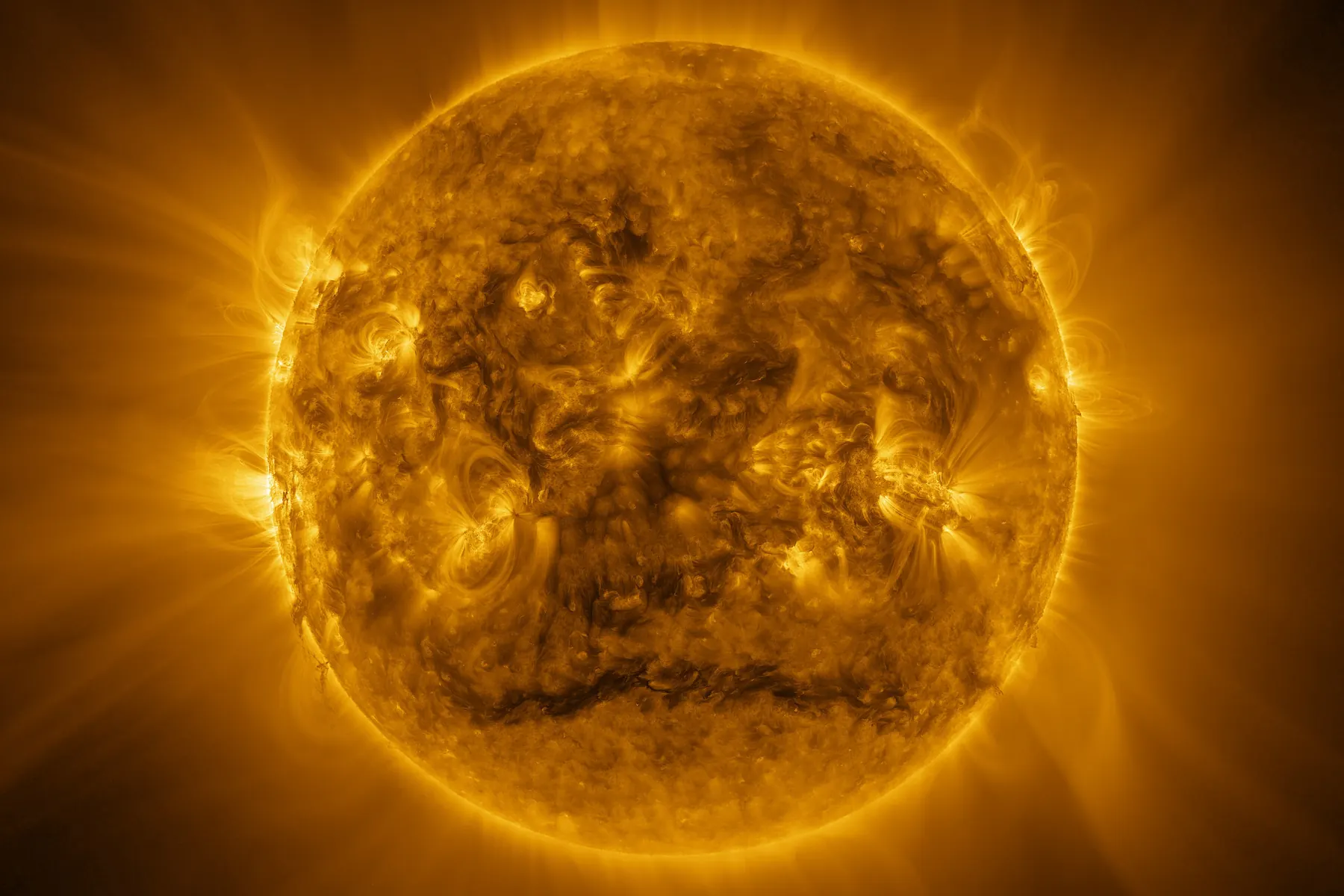 The full disc of the Sun in extreme ultraviolet, showing loops and active regions in gold