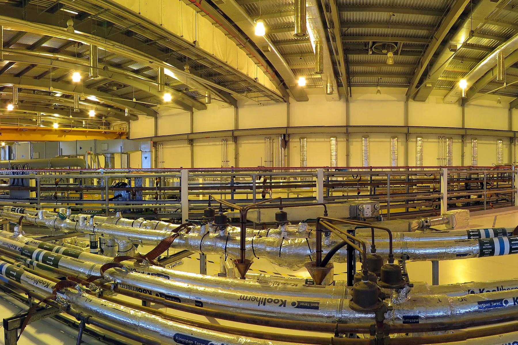 The curving interior of the Diamond Light Source synchrotron hall with beamline equipment