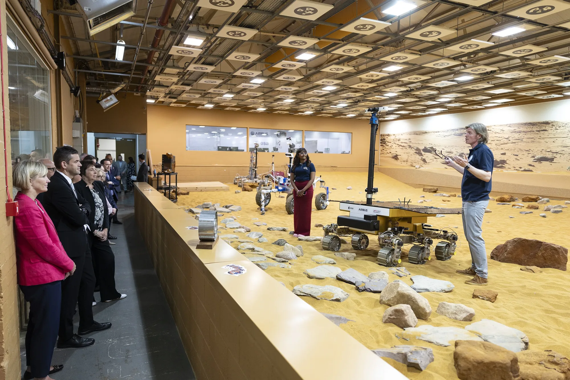 Engineers with Mars rover prototypes on the simulated Martian terrain of the Mars Yard at Airbus Defence and Space in Stevenage